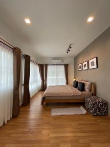 Ban Khlong PrawetAnnaHome89/63@Latkrabang的一间卧室配有大床和窗帘