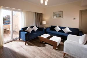赫尔格达Swiss Inn Resort Hurghada的客厅配有蓝色的沙发和桌子
