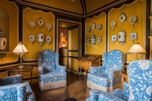 Courcelles-sur-Vesle科赛尔城堡酒店的一间墙上有两把椅子和一张桌子及盘子的房间