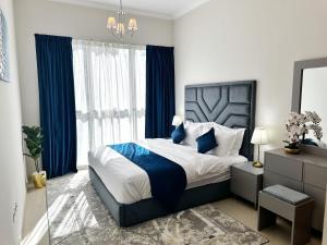 迪拜Dunya Tower Luxury and 2 min walk to Dubai Mall and Burj Khalifa的一间卧室配有一张带蓝色窗帘的大床