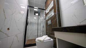 迪亚巴克尔Mitra otel的浴室配有淋浴和带水槽的卫生间。