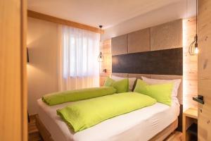 圣洛伦佐因巴纳莱B&B al Borgo的一间卧室配有一张带绿色枕头的床