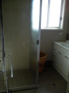 诺拉灰色鹅卵石公寓的带淋浴的浴室和玻璃门