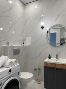 阿斯塔纳Уютная квартира в городе Астана, возле Барыс арена的浴室配有卫生间、盥洗盆和洗衣机。
