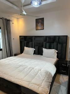 BrusubiThe Retreat Apartments的一间卧室配有一张大床和黑色床头板