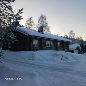 罗瓦涅米A room (or 2 or 3) in a Lapland House of Dreams的小木屋前面有一堆积雪