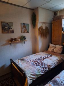 SteenbergenB&B de Vrijheid en de Ruimte in Steenbergen的一间卧室配有一张带长颈鹿毛毯的床
