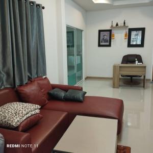 北碧Bann Sukjai的客厅配有棕色皮沙发