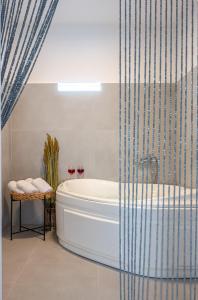 Nea Cryssi AktiNoho Villas @ Sunlit house Paros的一间带浴缸和淋浴的浴室