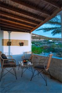 Nea Cryssi AktiNoho Villas @ Sunlit house Paros的美景庭院设有两把椅子和一张桌子