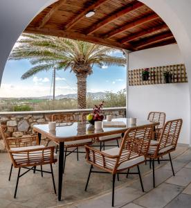 Nea Cryssi AktiNoho Villas @ Sunlit house Paros的棕榈树庭院里的桌椅