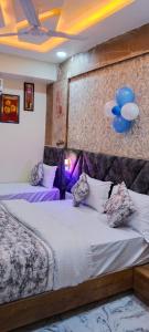 艾哈迈达巴德Hotel Primeland villa Gota的一间卧室设有两张带紫色床单和蓝色气球的床。