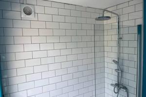 布里斯托Collingwood House by StayStaycations的浴室铺有白色瓷砖,设有淋浴。