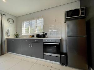 德班Cosy Comfort Guest Suit的厨房配有不锈钢冰箱和微波炉。