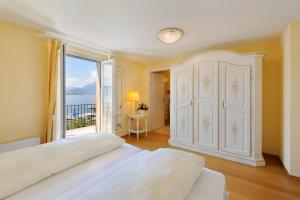 韦吉斯斯霍夫湖滨酒店的卧室设有大型白色橱柜和窗户。