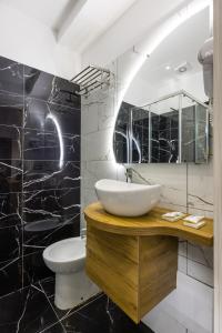 那不勒斯那不勒斯贝拉酒店的一间带水槽、卫生间和镜子的浴室
