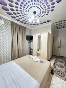 TürkistanLux的一间卧室配有一张紫色天花板的床