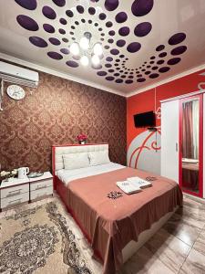 TürkistanLux的一间卧室配有一张红色墙壁的床