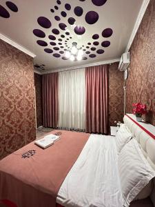 TürkistanLux的一间卧室设有一张大床,天花板上配有紫色点