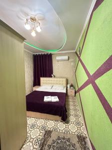 TürkistanLux的小房间设有床和绿色的墙壁
