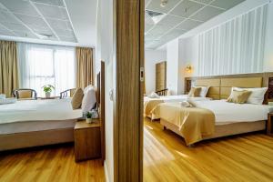 布加勒斯特SIR FUNDENI HOTEL的酒店客房设有两张床和窗户。