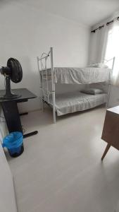 乌尼昂-达维多利亚Apartamento inteiro com garagem coberta的客房设有两张双层床和一张书桌。