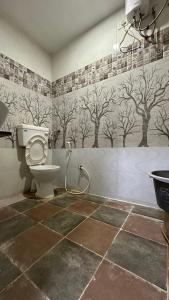 巴罗达Hotel New Shiv Kunj的设有带卫生间的浴室,墙上有树木