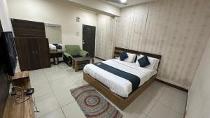 巴罗达Hotel New Shiv Kunj的一间卧室,卧室内配有一张床和一把椅子
