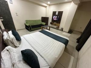巴罗达Hotel New Shiv Kunj的一间卧室配有一张床、一把椅子和电视