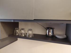 安曼Gentle Breeze Studio1的一个带四件玻璃物品的厨房架