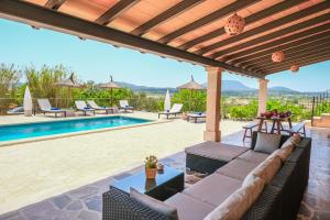 蒙图伊里Finca Son Roca by Rentallorca的一个带沙发和游泳池的户外庭院
