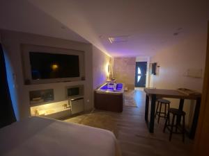 Saint-VictoretCôté spa的客房设有1张床、1张桌子和1台电视。