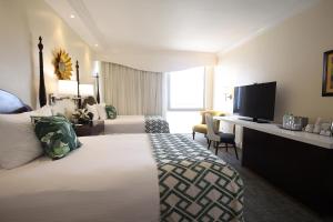 金斯敦考特利酒店及套房的酒店客房设有一张大床和一张书桌。