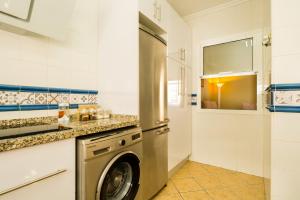 塞维利亚Casa unifamiliar的一间厨房,在房间内配有洗衣机和烘干机