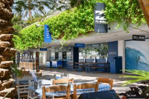埃拉特Royal Beach Eilat by Isrotel Exclusive的大楼内带桌椅的餐厅