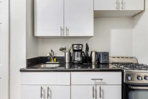纽约Modern NY Style 2BD Apartment in Upper East Side Manhattan的白色的厨房设有水槽和炉灶。