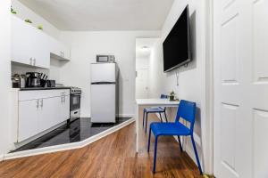 纽约Modern NY Style 2BD Apartment in Upper East Side Manhattan的厨房配有桌子、两把椅子和冰箱