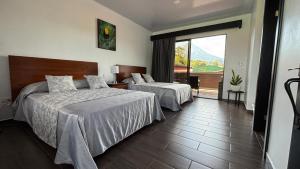 福尔图纳Arenal Monara的酒店客房设有两张床和一个阳台。