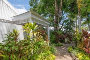 道格拉斯港Tropical Resort-style Living on Mirage Golf Course的白色的房子,有许多植物和树木