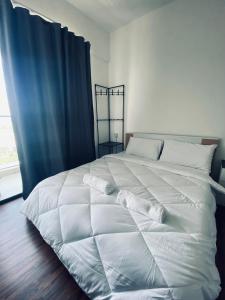 东贡岸Comfy suites的卧室内的一张带枕头的白色床