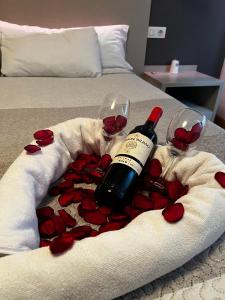 比亚雷亚尔Hello Villarreal Suites的一瓶葡萄酒和两杯红玫瑰