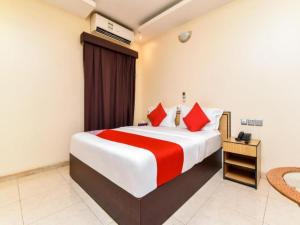 拉斯阿尔卡麦OYO Royal Plaza Residence -3的酒店客房配有一张带红色枕头的大床