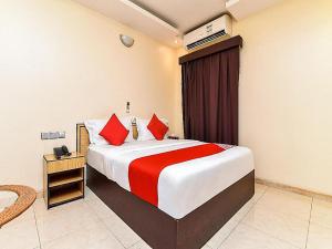拉斯阿尔卡麦OYO Royal Plaza Residence -3的一间卧室配有一张带红色枕头的大床