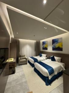 利雅德الحزم للشقق الفندقية - الرياض - العليا的酒店客房设有两张床和电视。