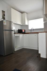 瓦尔迪维亚Cabaña de campo的厨房配有白色橱柜和不锈钢冰箱
