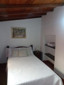 圣希尔Real Dream Hostel的卧室配有白色床和木制天花板