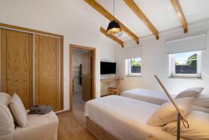 维拉诺瓦德卡塞拉Quinta da Bornacha - Casa A的酒店客房设有两张床和电视。
