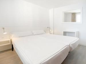卡拉米洛Apartamentos Morito Beach的白色卧室配有床和镜子