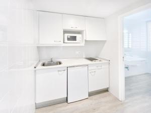 卡拉米洛Apartamentos Morito Beach的白色的厨房配有水槽和微波炉