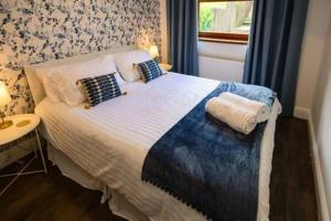 庞特普里德Heritage Cottage by StayStaycations的卧室配有带枕头的床铺和窗户。